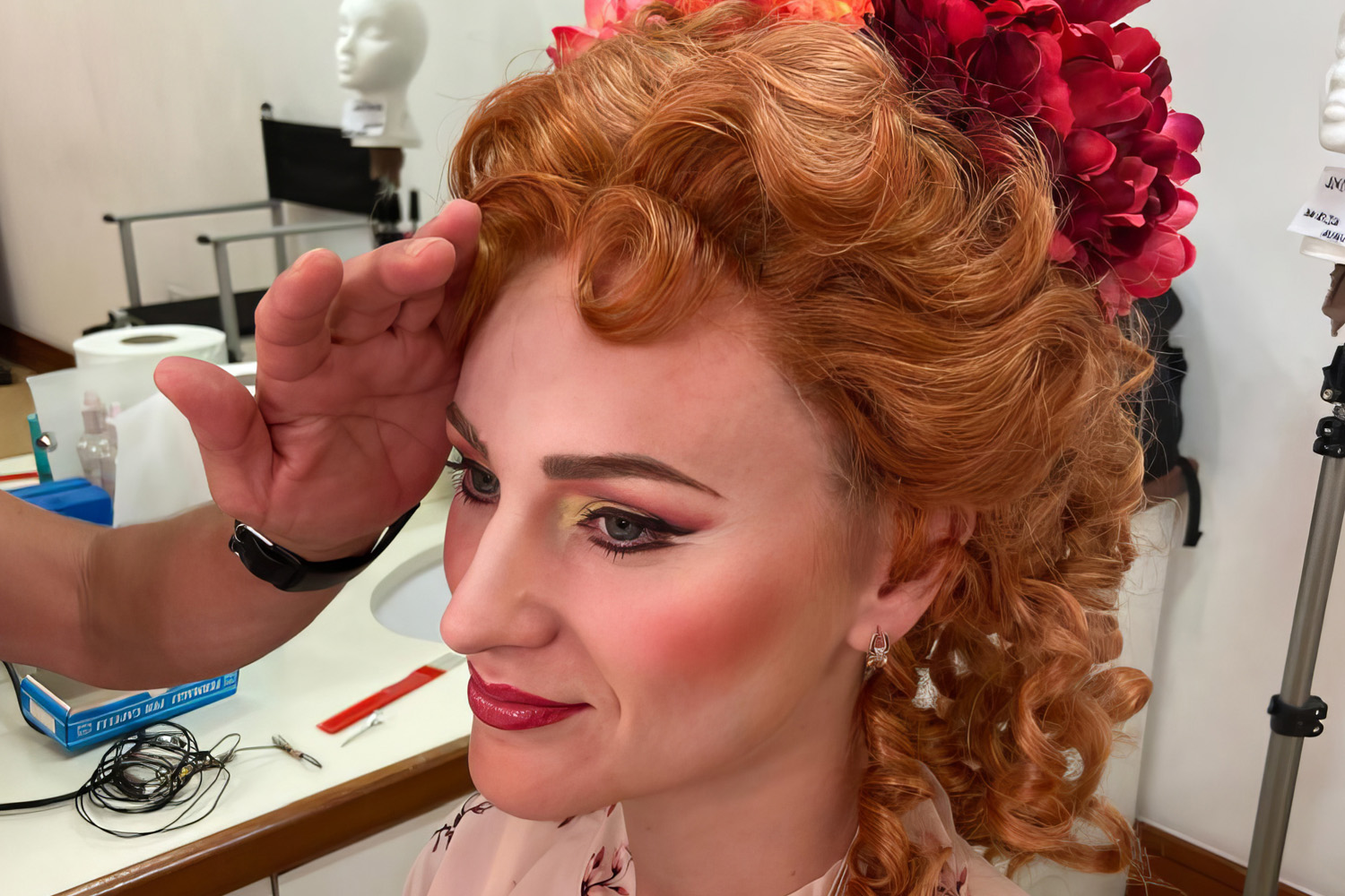 Performer having hair and a floral headpiece styled backstage